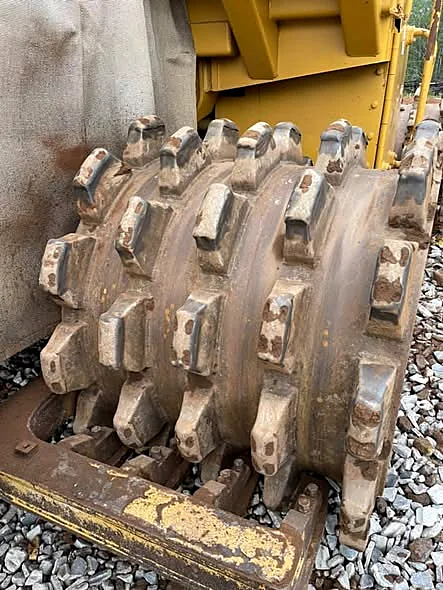 Worn Caterpillar 815 compactor wheel with worn tamping feet before refurbishment