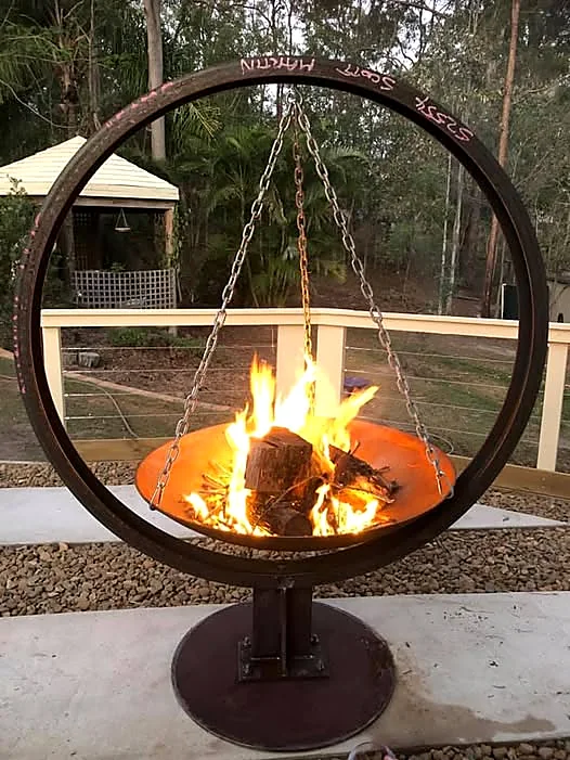 Custom suspended steel fire pit with live flames, fabricated by SM Mobile Welding